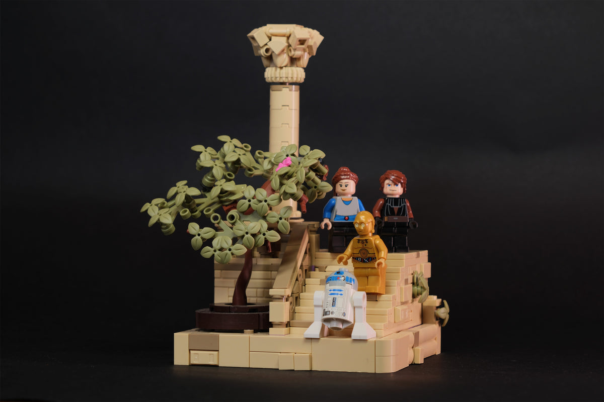 LEGO® Star Wars Diorama mit zwei Minifiguren sowie goldfarbenem und blau-weißem Droiden auf einer sandfarbenen Tempeltreppe Brick2D2